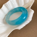 Detail view of sky blue resin bangle with marble texture inside a shell dish - Sky Blue Small Size Style