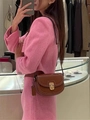 Primer plano de un bolso de silla en cuero marrón con costuras blancas y hebilla - Marrón