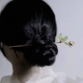 Close-up of a golden flower hair pin with light green petals on a brunette bun - Magnolia Flower Hair Stick