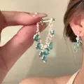 Detailed view of silver dangle earrings with light blue crystals and tassel chains - 5# 925 Sterling Silver Earring Post - Light Blue Gem