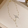 French style gold pearl necklace with zircon butterfly pendant on a beige jewelry tray - Zircon Pearl Butterfly Pendant Necklace