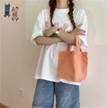 Close-up of orange canvas lunch bag held by a person wearing a white tulip print t-shirt - Orange (With Snap Button)