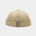 Detailopname van beige docker-muts met M-geweven label en katoenen twill-textuur - Verstelbaar / Beige