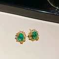 Detailed close-up of 18k gold plated stud earrings with green oval zircon and diamonds - Earrings Only / Gold-Blue