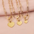 Three sizes of gold heart pendants on paperclip chain necklaces against pink fabric - 10mm / 18K Gold