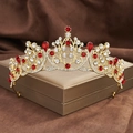 Detail der goldenen Barockkrone mit roten Strasssteinen auf dunklem Samthintergrund - Gold mit roten Strasssteinen