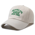 Klassische beige Baumwolle Baseballkappe mit grüner Brooklyn-Stickerei in 45-Grad-Ansicht - Einheitsgröße / Gebrochenes Weiß