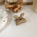 Macro shot of elegant matte beige hair claw clip with golden metal spring detail - Coffee Brown Bow
