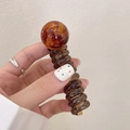Spiral telephone cord hair tie with amber tortoiseshell bead and transparent brown finish - Caramel color