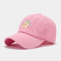 Close-up of pink baseball cap featuring detailed floral and STUDIO embroidery on fabric - Pink
