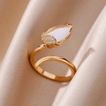 Detailed close-up of a gold tulip ring with white petal and zircons on beige silk fabric - Gold White Tulip (G6095183)