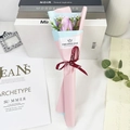 Detailed view of single purple soap rose in pink and blue wrap with red ribbon - Elegant Purple Rose