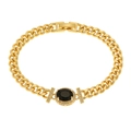 Macro detail of gold link bracelet featuring a large oval black stone with diamond accents - Black
