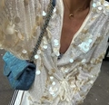 Detail of long sleeve top with beige sequins paired with blue denim chain bag - White