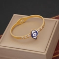 Dettaglio del bracciale occhio di Allah dorato con smalto blu e accenti di cristalli - Stile Malocchio con Strass (1#)