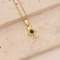 Detailed close-up of golden bear necklace with a blue heart zircon on beige stones - Dark Blue Heart Stone Bear (2#)