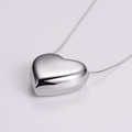 Close-up of polished silver heart pendant with minimalist snake bone chain necklace - Large / Steel