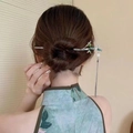 Detail of silver metal hairpin featuring a green dragonfly and elegant silver tassels - Bamboo Stem Silver