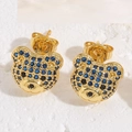 Detail shot of cute gold bear earrings featuring blue and black micro-set cubic zirconia - Little Bear Studs / Gold Royal Blue Zirconia