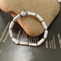 Detailed shot of white turquoise beaded elastic bracelet on natural stone and magazine - White Turquoise