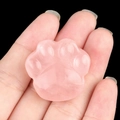 Handheld rose quartz cat paw carving with smooth polished finish on black background - Rose Quartz