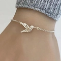 Detail of silver hummingbird pendant bracelet with intricate cutout patterns on a wrist - Hummingbird Bracelet / Silver