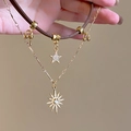 Gros plan sur un collier double rang avec cordon cuir, chaîne dorée et pendentifs étoilés - 2# Style Étoile Or Brun