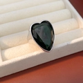 Close-up of heart-cut dark green zircon ring with wide silver band on velvet display - Silver-Black