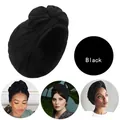 Detailansicht eines schwarzen Turban-Kopfwickels mit Falten und Knotendesign-Stoff - Schwarz
