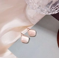 Elegant rose gold square stud earrings featuring pink cat eye stones on silk background - Pink Square Cat Eye Studs
