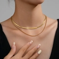 Close-up of layered 18k gold plated jewelry with snake chain and box chain textures - Gold Layered Snake & Box Chain