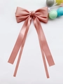 Détail d'un nœud papillon en satin rose avec de longs rubans et une texture lisse - Rose