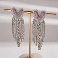 Dettaglio degli orecchini a cuore rosa con strass e lunghe nappe argentate su supporto - Perno per orecchini in argento - Rosa