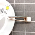 Nahaufnahme einer minimalistischen goldenen Haarklammer auf einem weißen Keramikteller - 7.5cm Hohl Clip / Gold