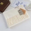 Close-up of soft beige cashmere scarf with long tassels and woven label on aesthetic layout - Milk White / 200cm