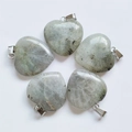 Five grey translucent natural crystal heart pendants with silver metal bails on white background - Labradorite