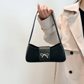 Chic black baguette bag with golden bow hardware and slim shoulder strap for women - Black
