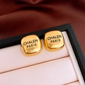 Macro detail of golden square earrings with brushed metal finish and luxury text engraving - Gold