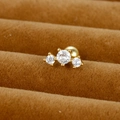 Vue macro de boucles d'oreilles à trois zircons ronds et fermoirs à boule dorés - Arc à Trois Pierres / Or / 0,1