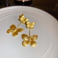 Detail of golden double-layer butterfly earrings with brushed metal texture on ceramic tray - Gold Double-Layer Brushed Butterfly (72#)