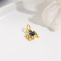 Gold spider pendant featuring heart-shaped blue zircon stone on a white display tray - Dark Blue