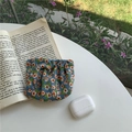 Portable floral squeeze coin purse in blue fabric on an open book outdoor background - Chiffon Blue Floral