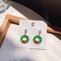Detail of Christmas wreath earrings with green enamel and small crystals on a card - Christmas Wreath