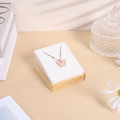 Détail d'un pendentif papillon en pierre rose sur un support à bijoux en velours blanc - Support Pendentif 7*8 / Velours Beige