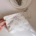 Detail of blue bow print canvas bag with pearl strap and simple wish woven label - White Base Light Blue Butterfly Knot