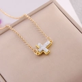 Elegant gold cross necklace with shimmering pavé inlay on a soft pink background - White
