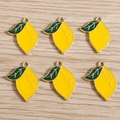 Set of six lemon-shaped alloy enamel charms with yellow fruit and green leaves on wood - Yellow