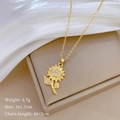 Detail of gold sunflower necklace with cubic zirconia on a beige jewelry box - Gold