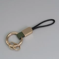 Porte-clés doré avec lanière en cuir vert foncé et boucle de cordelette noire - Vert + Or