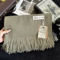Detail of soft olive cashmere shawl featuring fine fringe tassels and elegant product tags - 200x68cm / Tea Green